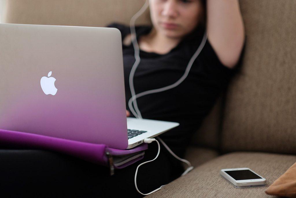 woman on couch doing online therapy
